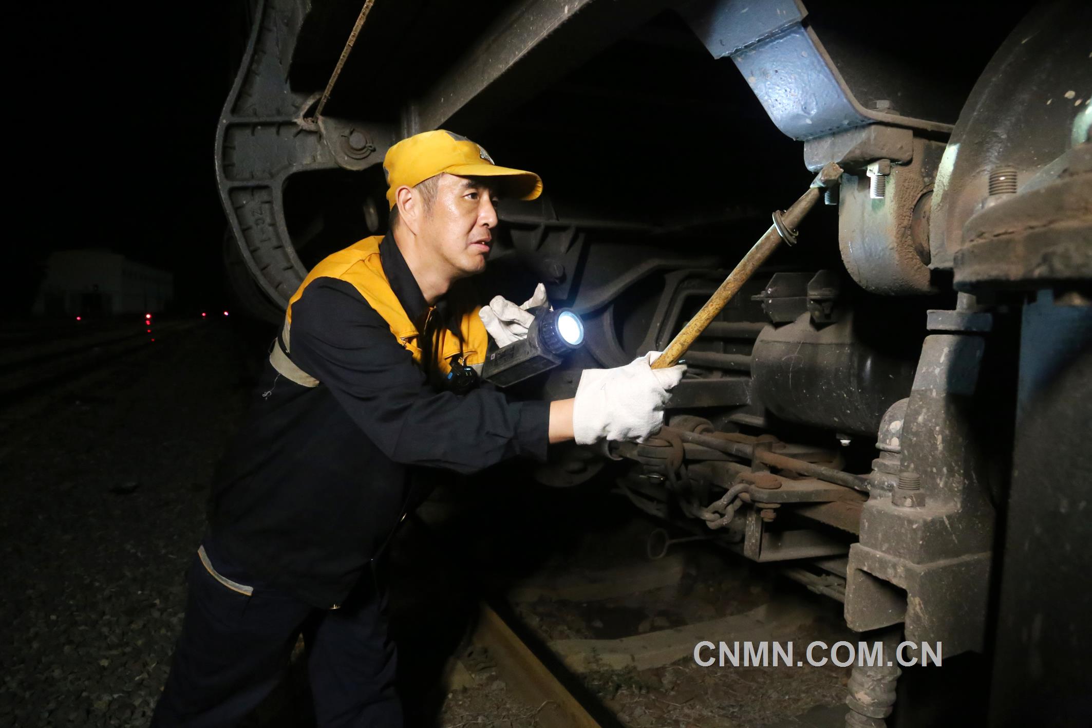 焦建智正在對待發礦石專列進行發車前的技術檢查。