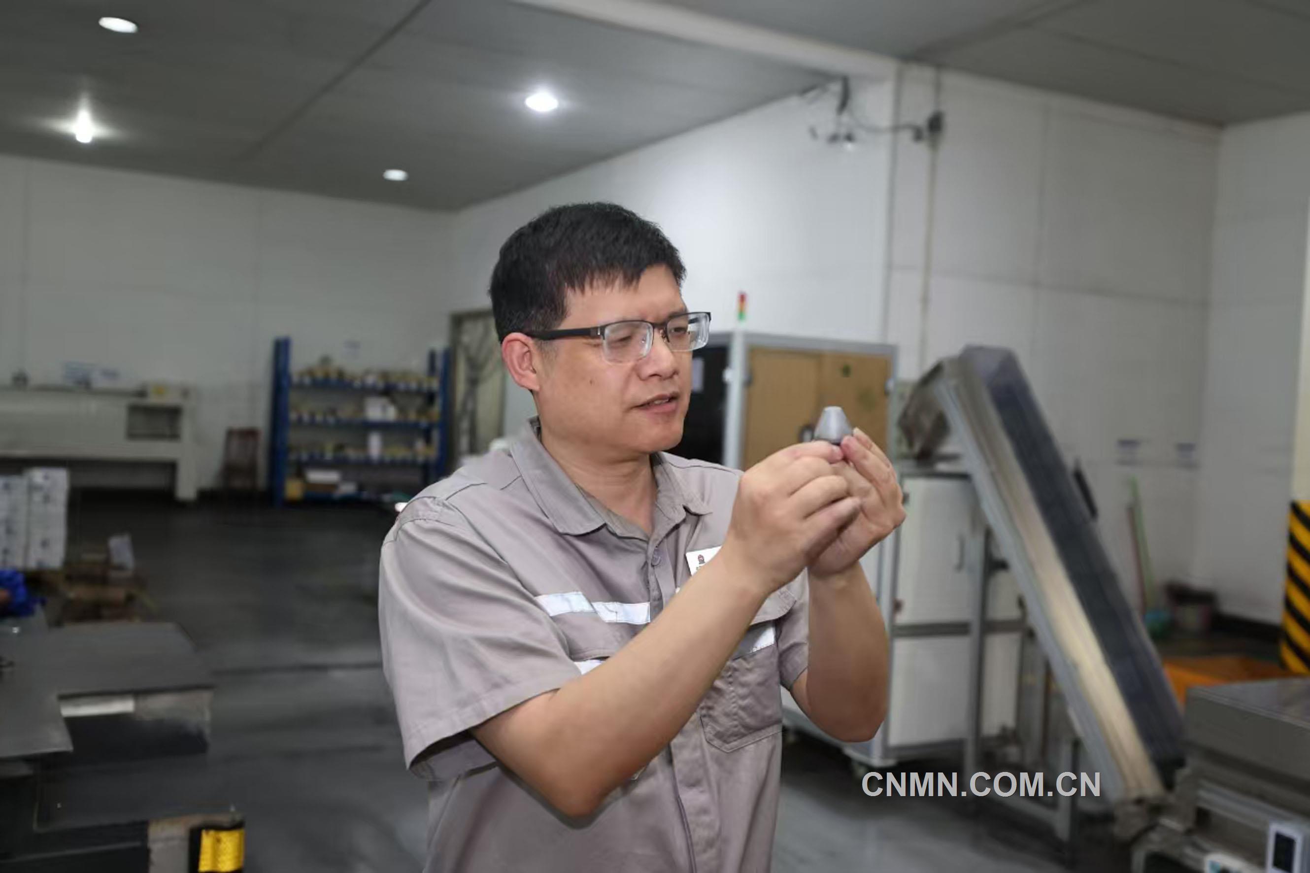 譚竹峰在對銑刨齒的表面質量進行檢查。