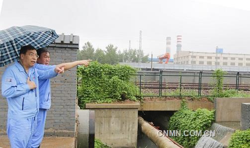 第二張:萬基控股集團董事長李躍民(左前)檢查萬基金屬鈉公司泄洪渠洪水流向